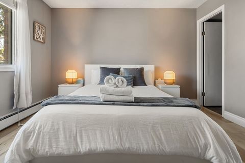 Drift off to sleep under the city lights, visible through large windows in our serene bedroom.