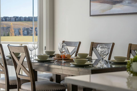 Dining area equipped with all dinner ware, including wine glasses.