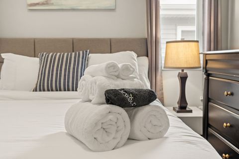 Drift off in comfort with our queen bed, outfitted with fresh, plush bedding and accented by modern dimmable night lamps.