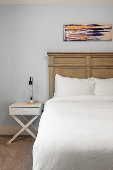 Drift off in comfort with our comfortable bed, outfitted with fresh, plush bedding and accented by modern dimmable night lamps.