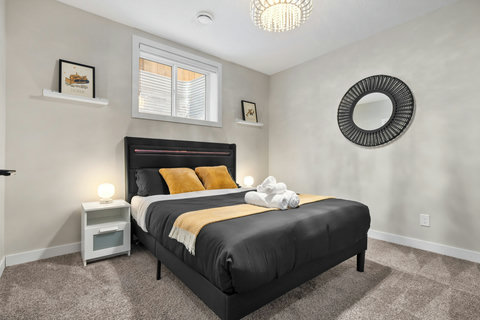 Stylish guest bedroom featuring a plush black bed and warm gold décor