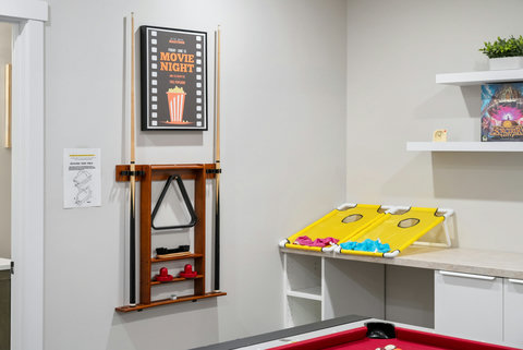 Fun-filled game room featuring cornhole, classic popcorn machine, and pool table
