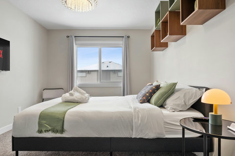 Bright guest bedroom with comfortable queen bed and scenic mountain outlook