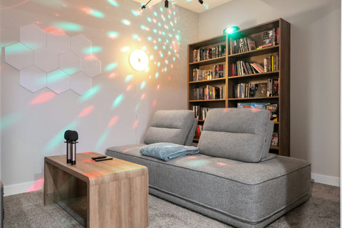 Stylish living room featuring interactive hexagonal wall art and mood lighting