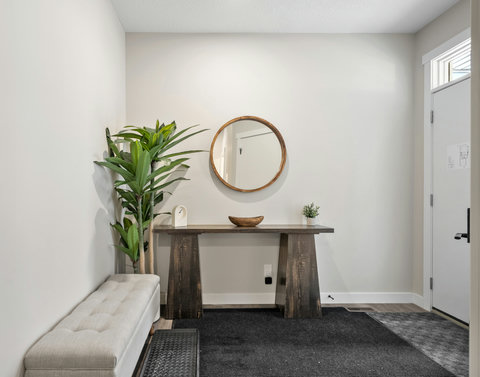 Welcoming entryway featuring a wooden console table and decorative mirror