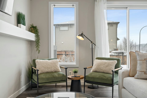 Light-filled living room with mid-century seating and urban views