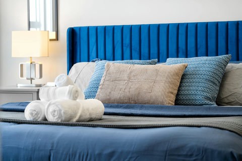 Luxurious bedroom with striking blue velvet headboard and thoughtful amenities
