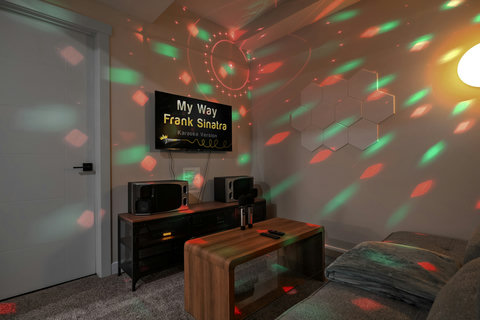 Sing your heart out in this vibrant private karaoke lounge with dynamic mood lighting