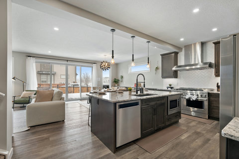 Chef's kitchen with granite island, premium appliances, and seamless living space flow
