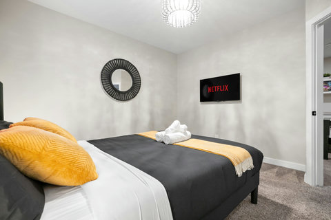 Stylish guest bedroom with Netflix-ready entertainment and cozy touches