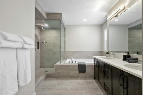 Luxurious master bath with rainfall shower and deep soaking tub.