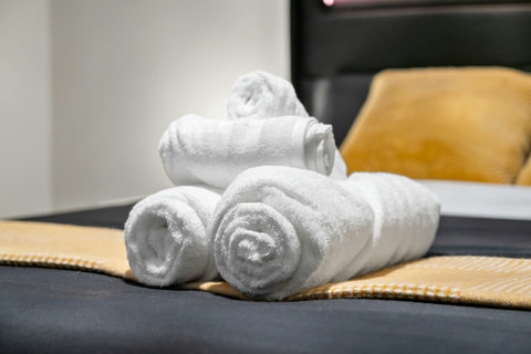 Thoughtfully rolled towels welcome you to a cozy guest bedroom