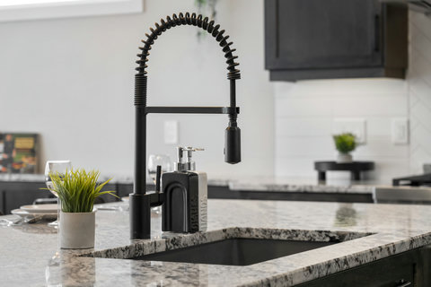 Sleek modern kitchen featuring a stylish black spring faucet and elegant granite counters