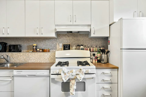 Bright, well-equipped kitchen with modern appliances and warm wood countertops