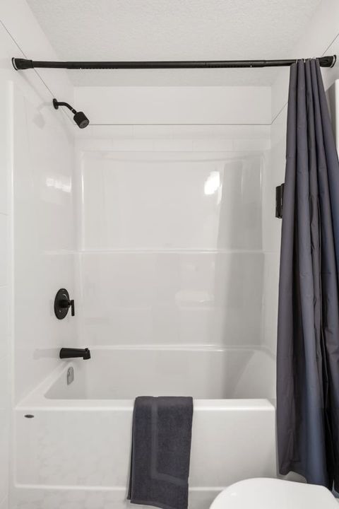Modern Master Bathroom with Sleek Fixtures and Contemporary Design, Stocked with Shampoo, Conditioner, and Body Wash for Your Convenience