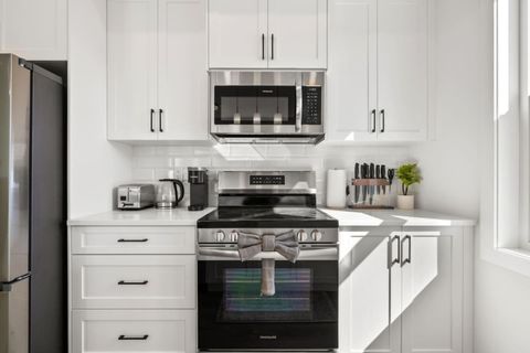 Modern Kitchen with Advanced Stone Stove Top Technology and a Microwave, Along with New Appliances, Spices, Kitchen Knives, and Utensils for a Fully Equipped Cooking Experience