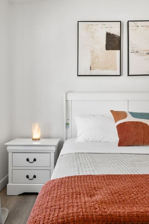 Comfortable queen bedroom featuring rich red decorative details, creating a cozy and inviting atmosphere