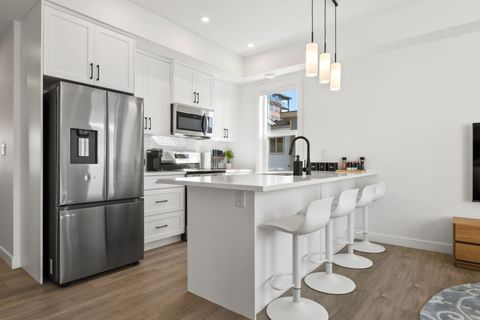 Modern Kitchen Equipped with All the Essentials: Dishwasher, Refrigerator, Microwave, Oven, and Sleek Stove Top for a Seamless Cooking Experience