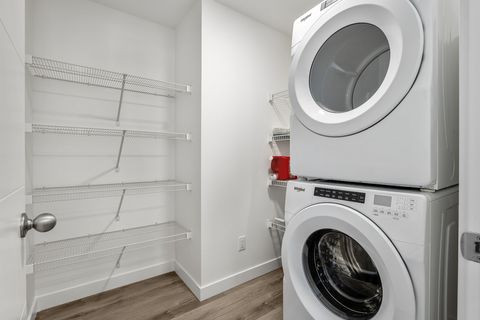Well-equipped laundry room with modern stacked appliances and shelving