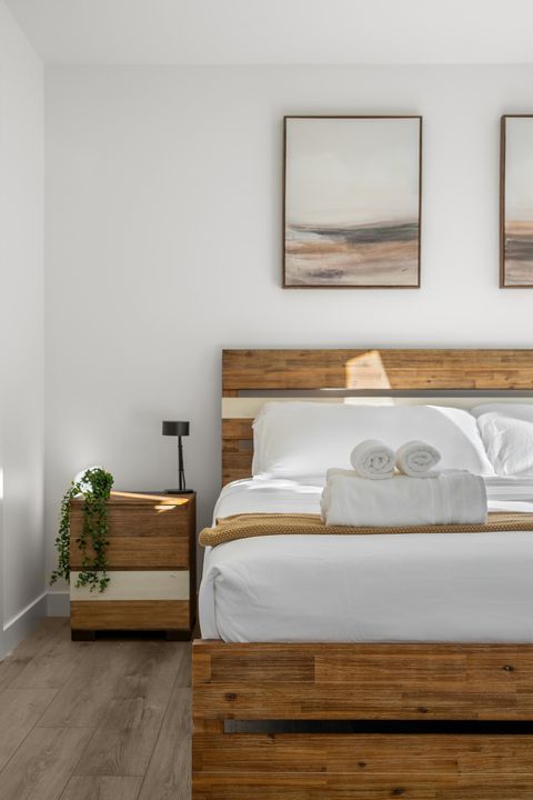 Serene guest bedroom with warm wood furnishings and crisp white bedding