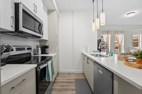 Stylish galley kitchen with stainless steel appliances and modern pendant lights