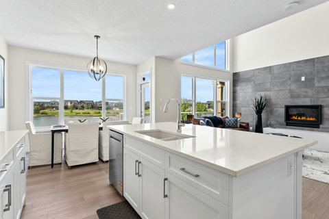Bright open kitchen flows seamlessly into dining and living spaces with stunning water views