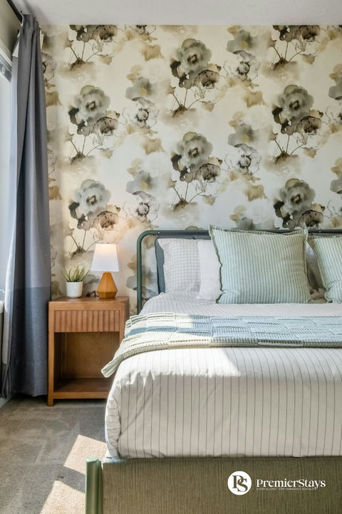 Charming guest bedroom with botanical wallpaper and soft linens