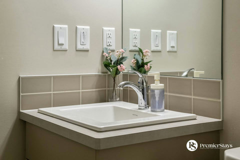 Bright, modern bathroom with fresh flowers and contemporary fixtures.