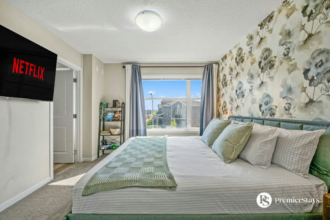 Bright, comfortable bedroom with scenic views and entertainment setup