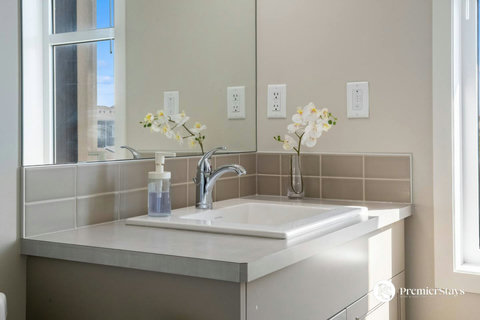 Sleek modern bathroom featuring a stylish vessel sink and fresh orchids