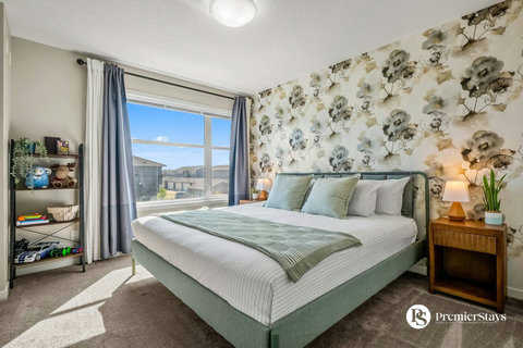 Bright main bedroom with luxurious bedding and stunning city skyline views