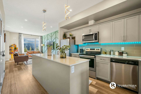 Chef's kitchen featuring sleek island, modern appliances, and turquoise accents