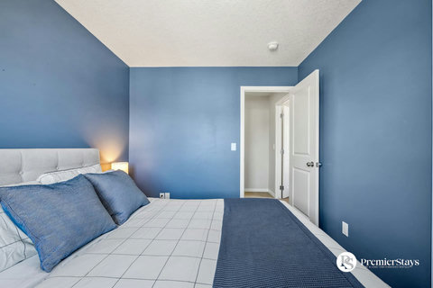Cozy guest bedroom with vibrant blue walls and private bathroom access
