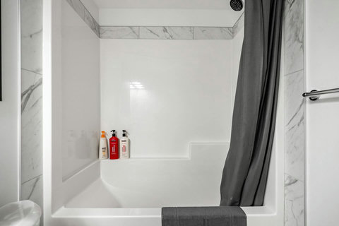 Luxurious walk-in shower with elegant marble tile and convenient storage