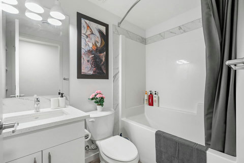 Sleek modern bathroom featuring a clean white vanity and shower-bath combination.