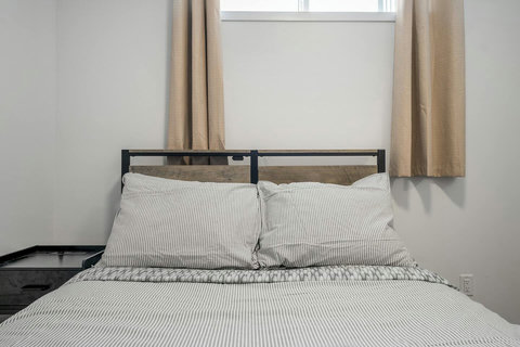 Cozy guest bedroom with soft striped linens and bright natural light