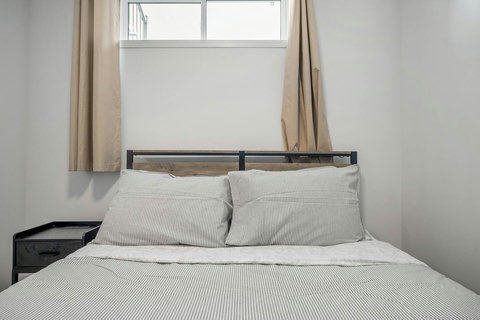 Serene guest bedroom with crisp striped linens and bright windows