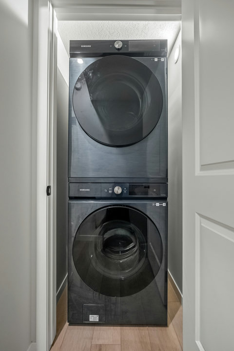 Modern in-unit laundry with stacked washer and dryer for convenience