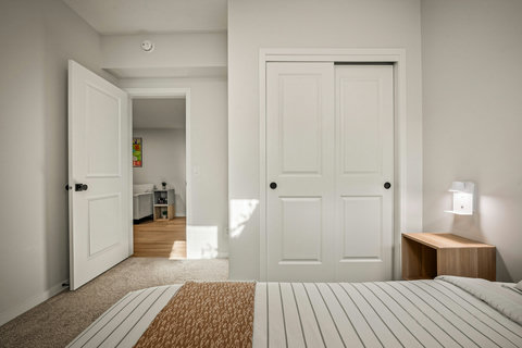 Comfortable guest bedroom with ample storage and natural sunlight throughout
