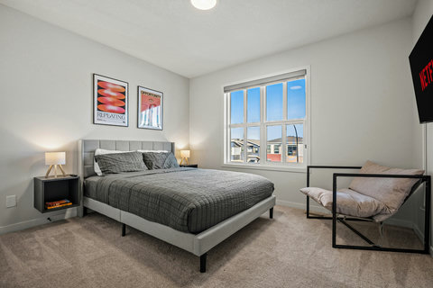 Bright guest bedroom with comfortable seating nook and plenty of natural light