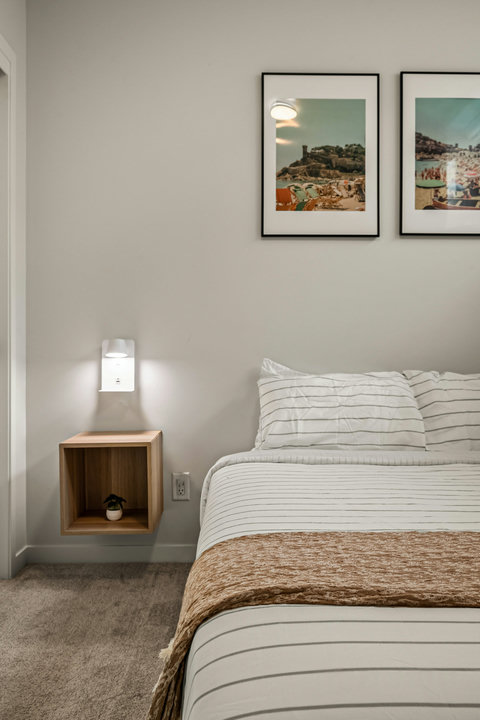 Serene guest bedroom with coastal-inspired artwork and natural light
