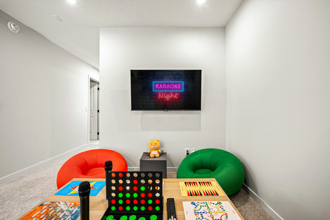 Fun karaoke room with neon sign, games, and colorful seating