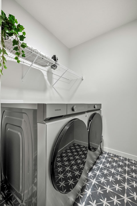 Convenient laundry room with modern Samsung appliances and stylish tile flooring