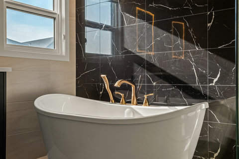 Spa-like master bathroom with elegant soaking tub and marble accents