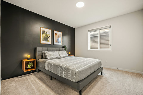 Stylish guest bedroom with dark accent wall and contemporary furnishings