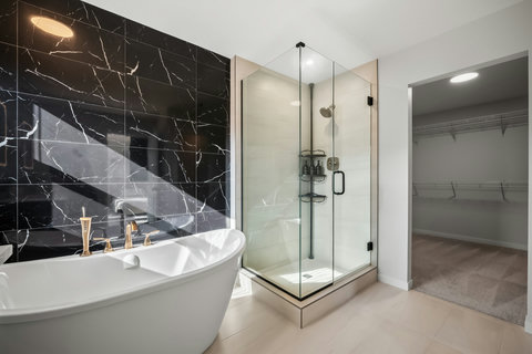 Spa-like master bath featuring marble accents and soaking tub