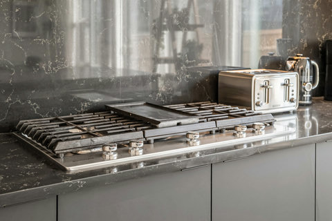 Sleek kitchen featuring professional gas cooking and elegant marble surfaces
