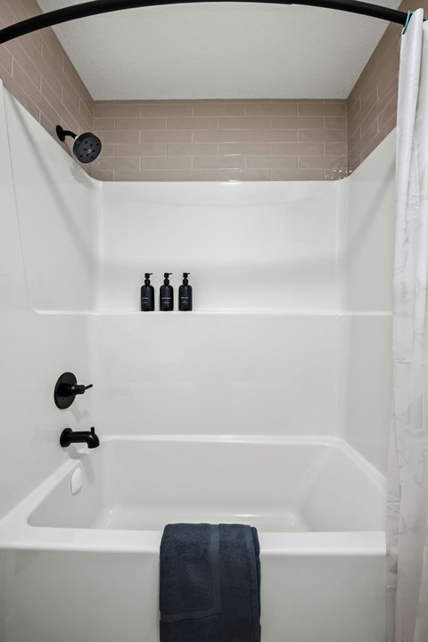 Sleek bathroom featuring a spacious shower with contemporary black accents