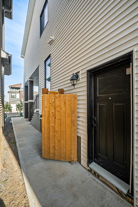 Private side entrance with charming wooden gate and modern patio