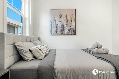 Serene guest bedroom with natural light and curated city skyline artwork
